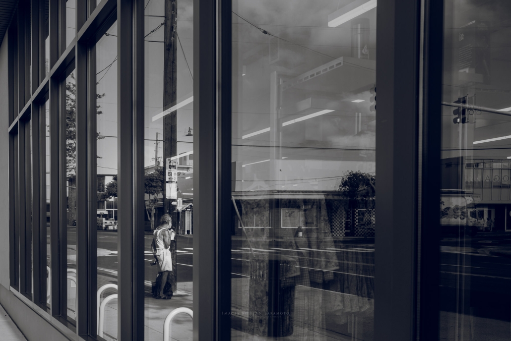 Street photography of a man waiting for his morning bus ride.