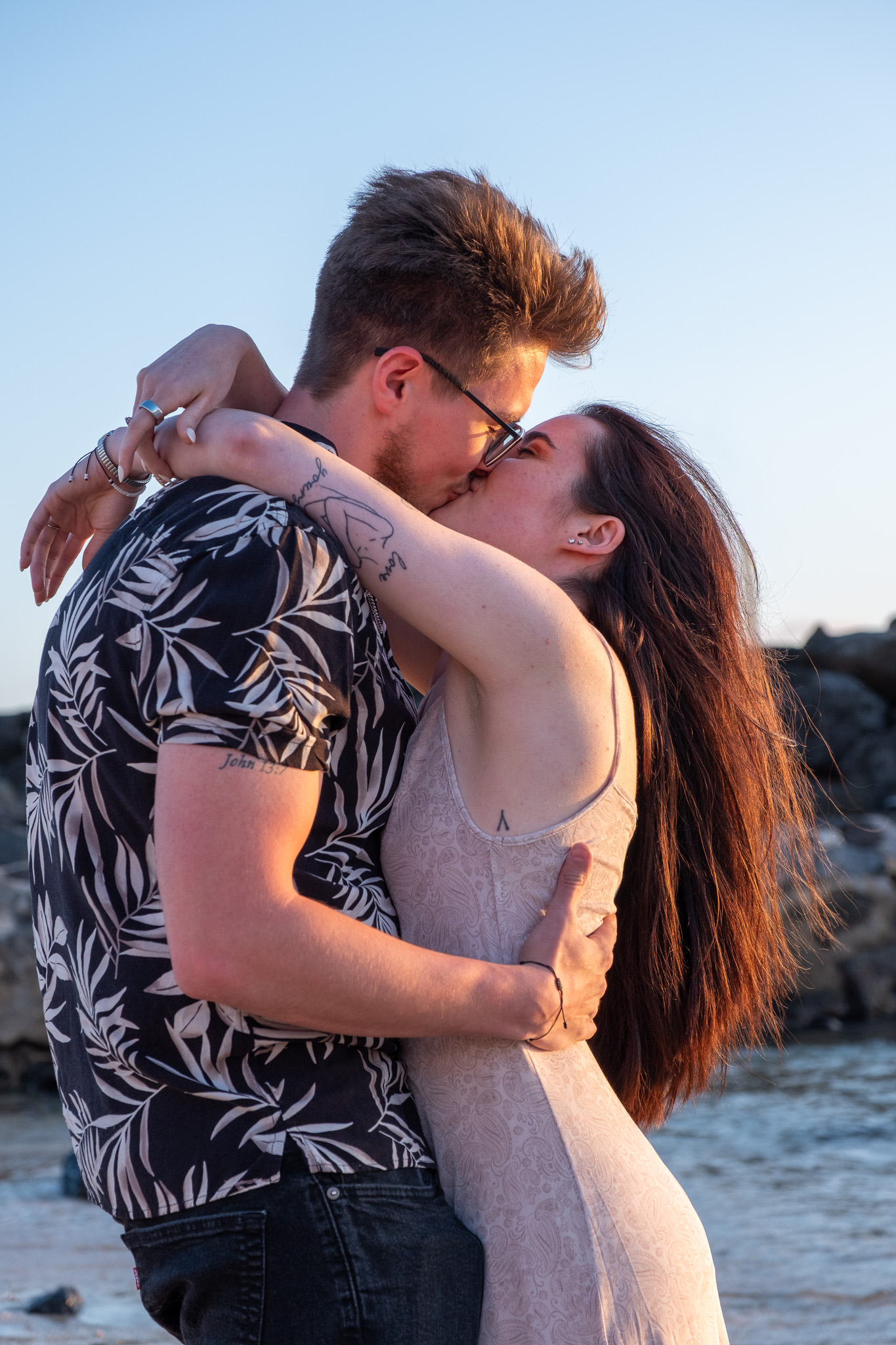 Honolulu Engagement Surprise Proposal Photographer Oahu An Oahu photographer captures a romantic sunset kiss. Professional Honolulu photography for a surprise proposal and engagement session on a beautiful beach.