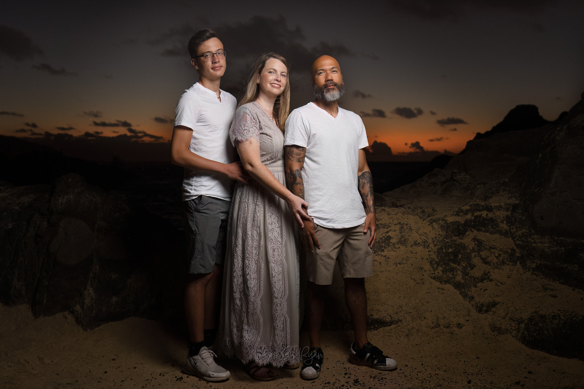 Honolulu Family Ohana Portraits Photography Oahu Photographer A Honolulu photographer captures family ohana portraits at dusk. A family of three poses on an Oahu beach during a professional sunset photography session.