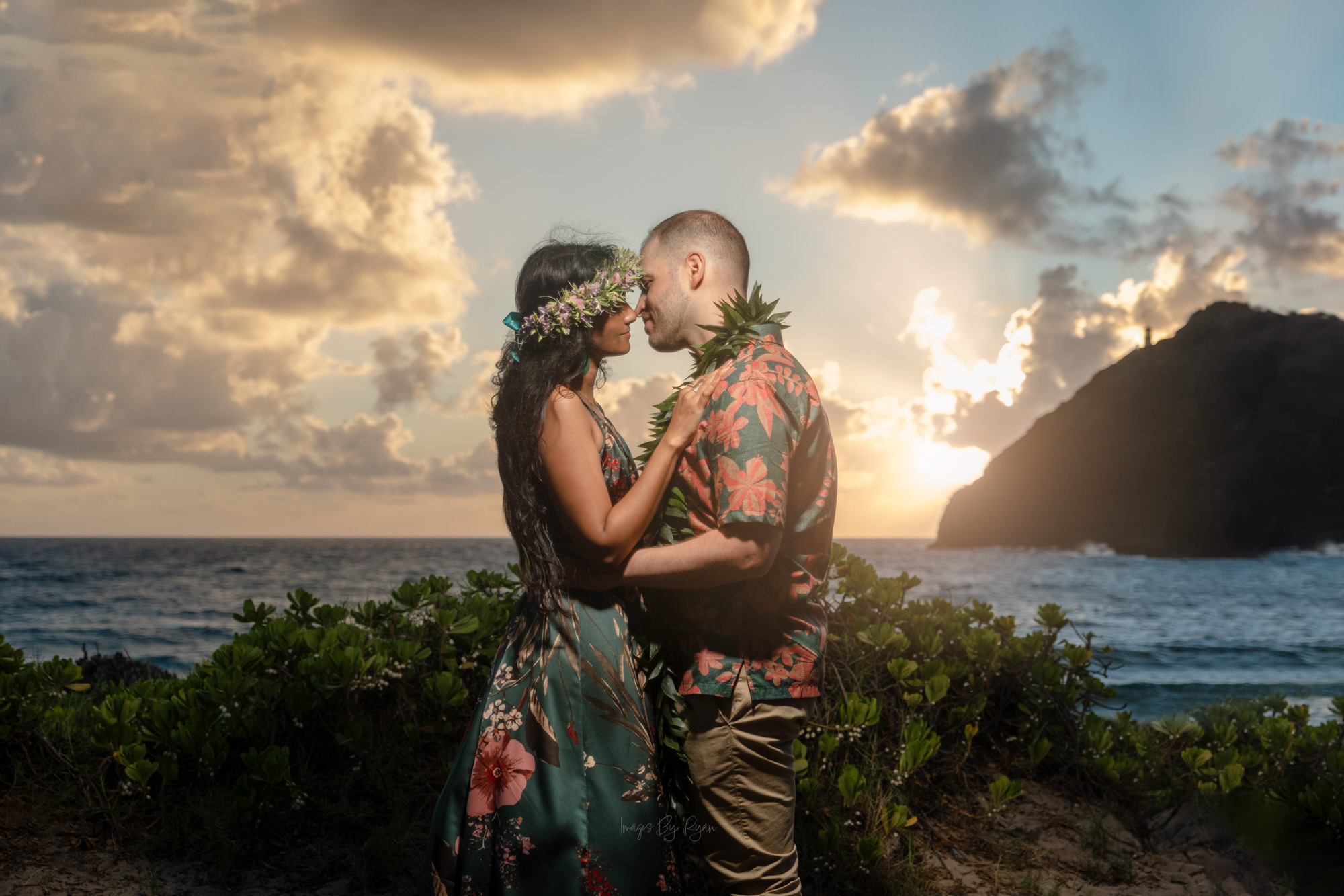 Honolulu Engagement Surprise Proposal Photography Oahu Professional photographer captures a surprise proposal on Oahu. A couple embraces at sunset in Honolulu, documenting their engagement with floral photography.