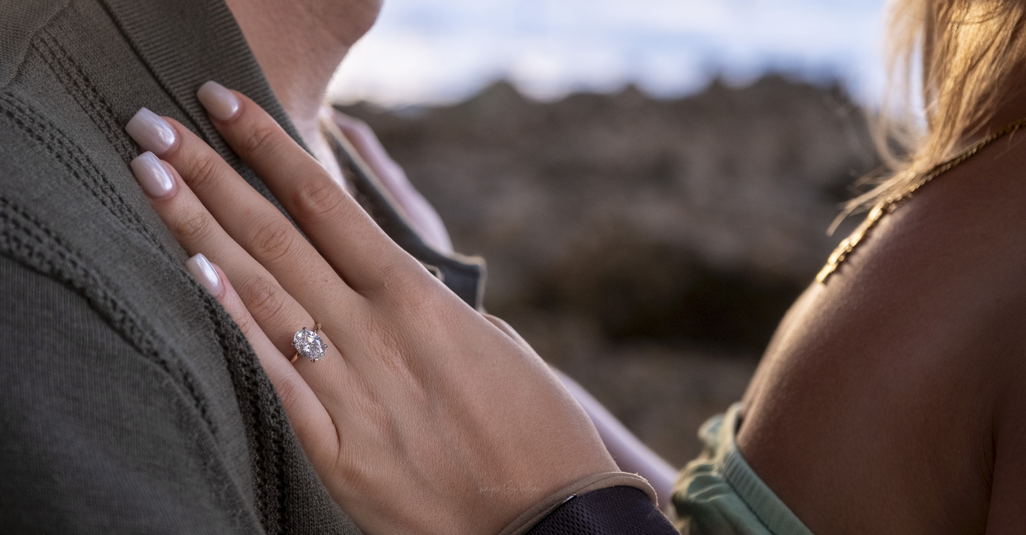 Close-up of an oval diamond engagement ring resting on a man's shirt during an Oahu portrait.
